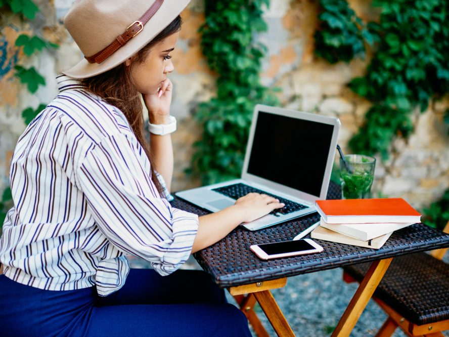 woman sitting at computer in garden